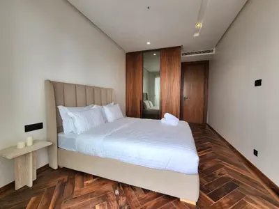 a bedroom with a large white bed and wooden floors at Casa finance city - Anfa Park - CFC in Casablanca