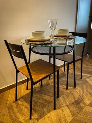 a glass table with two chairs and plates on it at Cozy Luxurious Bourgogne Studio in Casablanca