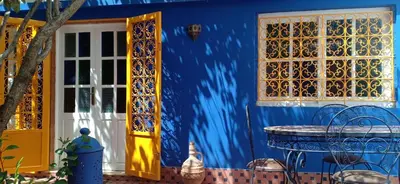 a blue house with a table and a blue wall at Taddart, Maison de vacances in Temara