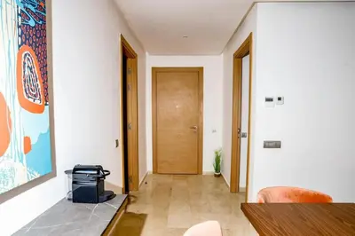 a hallway with a table and a wooden door at Moderne et luxueux in Rabat