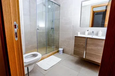 a bathroom with a shower and a toilet and a sink at Moderne et luxueux in Rabat