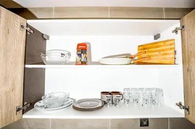 a shelf with dishes and glasses on it at Moderne et luxueux in Rabat