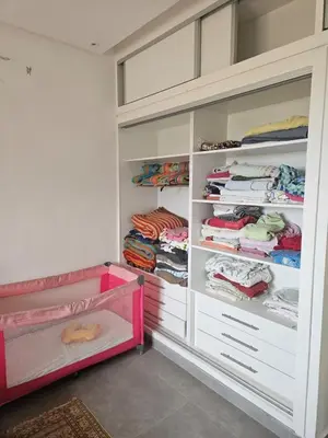 a walk in closet with white cabinets and a pink drawer at Premium farmhouse with pool in Rabat