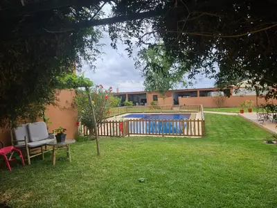 a yard with a fence and a swimming pool at Premium farmhouse with pool in Rabat