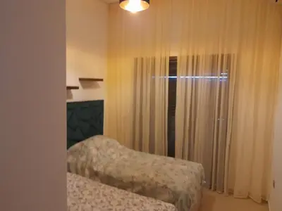 a bedroom with a bed and a window with curtains at Vacances Soleil Piscine & Plage Bouznika in Bouznika