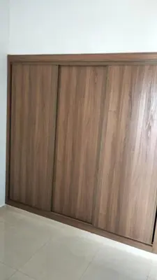 a wooden sliding door in a white wall at Vacances Soleil Piscine & Plage Bouznika in Bouznika