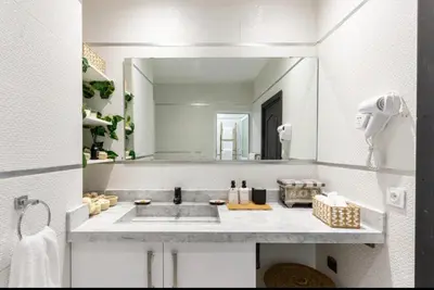 a bathroom with a sink and a large mirror at Villa en bord de plage, située dans une résidence à El Mansouria, idéale pour une grande famille ou pour des personnes seules in Mansouria