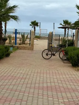 a bike parked on a brick walkway near the beach at Villa en bord de plage, située dans une résidence à El Mansouria, idéale pour une grande famille ou pour des personnes seules in Mansouria