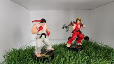 two toy figurines of superheroes standing on some grass at Sunny apartment with terrace near CasaFiananceCity in Casablanca