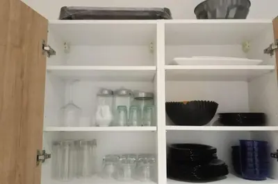 a white cabinet filled with glass bottles and dishes at Heaven Beach Front Apartment 2 Br in Sidi Rahal
