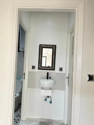 a white bathroom with a sink and a mirror at Chambre à Agdal Rabat dans un appartement partagé -king bed- in Rabat
