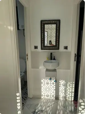 a white bathroom with a sink and a mirror at Chambre à Agdal Rabat dans un appartement partagé -king bed- in Rabat