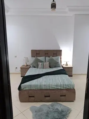 a bedroom with a large bed and two night stands at Garden Beach 2 sidi rahal in Sidi Rahal