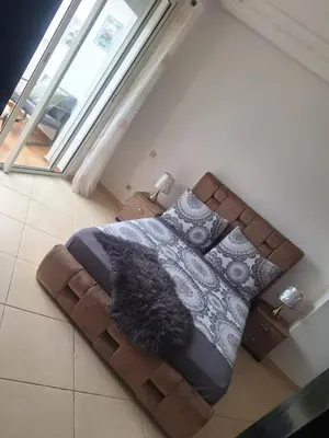 a bedroom with a bed with a blanket and pillows at Garden Beach 2 sidi rahal in Sidi Rahal