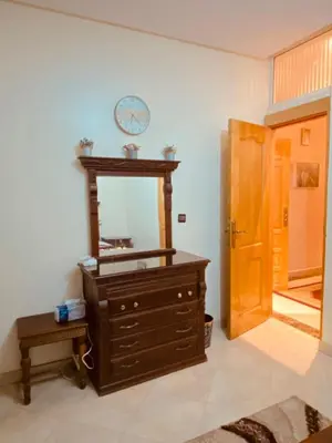 a dresser with a mirror and a clock on the wall at Luxurious Holiday Home 2 in Temara