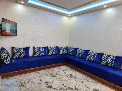 a blue couch with pillows in a room at Résidence Rose Marie 24 lot 92A à côté de Harhoura in El Harhoura