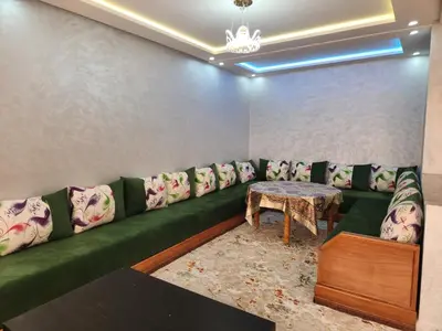 a living room with a green couch and a table at Résidence Rose Marie 24 lot 92A à côté de Harhoura in El Harhoura