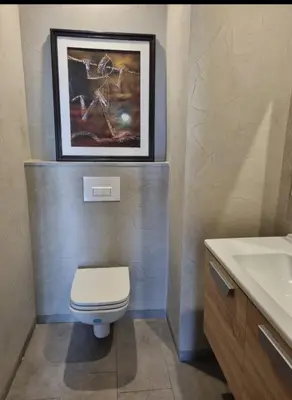 a bathroom with a toilet and a picture on the wall at Bel appartement à Harhoura in Oulad Kerroum