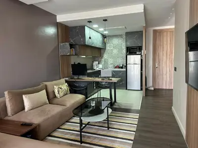 a living room with a couch and a kitchen at Modern City Centre Apartment in Casablanca