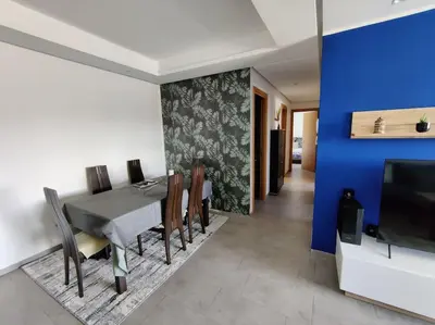 a dining room with a table and a blue wall at Blue Themed Vacation Condo in Temara