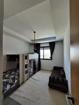 a bedroom with a bed and a couch in it at Blue Themed Vacation Condo in Temara