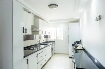 a white kitchen with white cabinets and a sink at At Casablanca 's Home in Casablanca