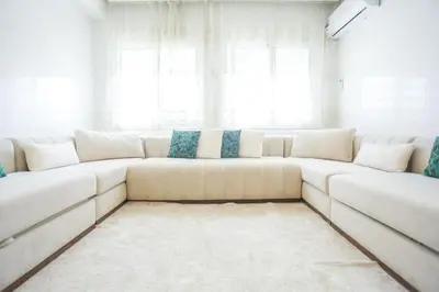 a white couch in a living room with windows at At Casablanca 's Home in Casablanca