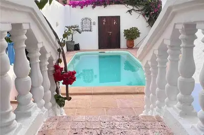 a small swimming pool in a house with a white staircase at Villa Taroub avec piscine et vue sur mer in Temara