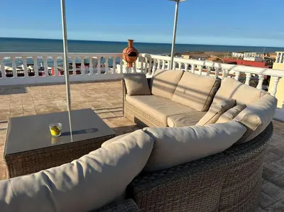 a living room with a couch and a table and the beach at Villa Taroub avec piscine et vue sur mer in Temara