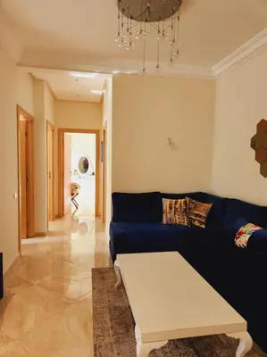 a living room with a blue couch and a table at Beach condo at Casabay plage Sidi Rahal in Casablanca