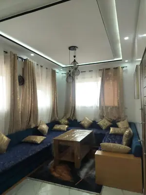 a living room with a blue couch and a table at Dahomey city in Bouznika