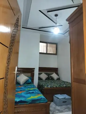 a small room with two beds and a window at Dahomey city in Bouznika
