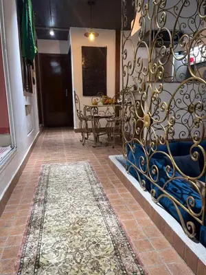 a hallway with a blue couch and a table at Lovely flat in nice garden in Rabat