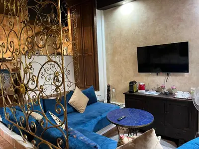a living room with a bed and a blue couch at Lovely flat in nice garden in Rabat