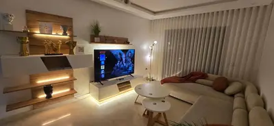 a living room with a couch and a flat screen tv at Appartement charmant au parc de Mohammedia, à seulement 2 pas de la plage in Mohammedia