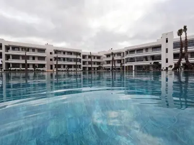 an empty swimming pool in front of a building at Appartement balnéaire magnifique à Mohammedia Mansouria in Mansouria