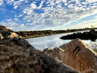 a view of a river with rocks and a cloudy sky at Zen and cosy Appart Rose Marie Kasbah in Skhirat
