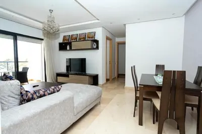 a living room with a couch and a table at Appartement avec piscine in Rabat