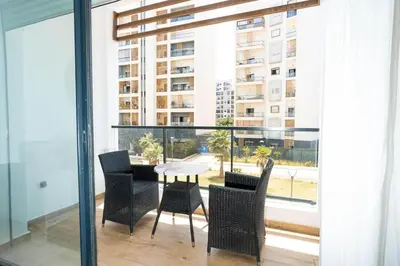 a dining room with a table and chairs on a balcony at Appartement avec piscine in Rabat