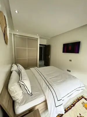a bedroom with a large bed with white sheets and pillows at Front of beach apartment marina yakht 2 in Casablanca