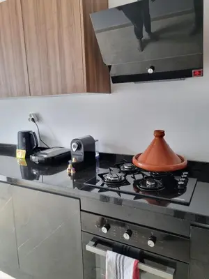 a kitchen with a stove with a tea pot on it at Appartement spacieux au cœur du Parc Proche plage Entre Casa et Rabat in Mohammedia