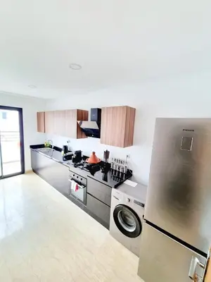 a kitchen with a stainless steel refrigerator and a stove at Appartement spacieux au cœur du Parc Proche plage Entre Casa et Rabat in Mohammedia