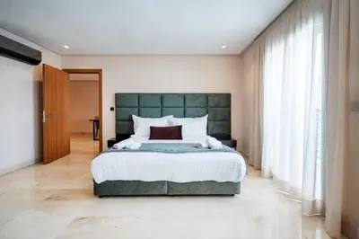 a bedroom with a large bed with a green headboard at AS Premium By Soho Hotels Maarif in Casablanca