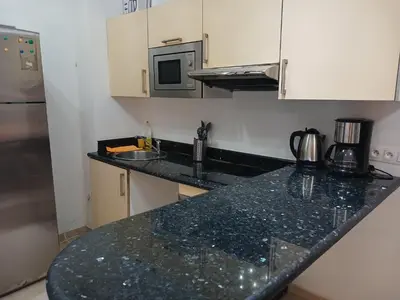a kitchen with a black counter top and a microwave at Boulevard Anfa in Casablanca