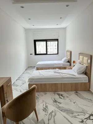 two beds in a white room with a window at Chambre à Agdal Rabat dans un appartement partagé -two single beds- in Rabat