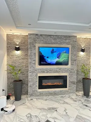 a living room with a tv on a stone wall at Chambre à Agdal Rabat dans un appartement partagé -two single beds- in Rabat