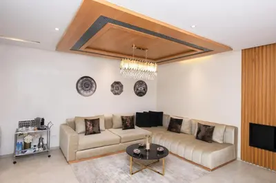 a living room with a couch and a tv at Appartement raffiné dans un quartier de luxe in Rabat