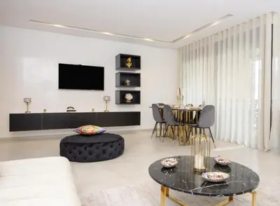 a living room with a couch and a table at Appartement raffiné dans un quartier de luxe in Rabat
