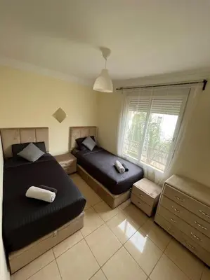 a bedroom with two beds and a window at Appartement Sidi Rahal in Sidi Rahal