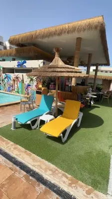 two chairs and an umbrella next to a pool at Appartement Sidi Rahal in Sidi Rahal